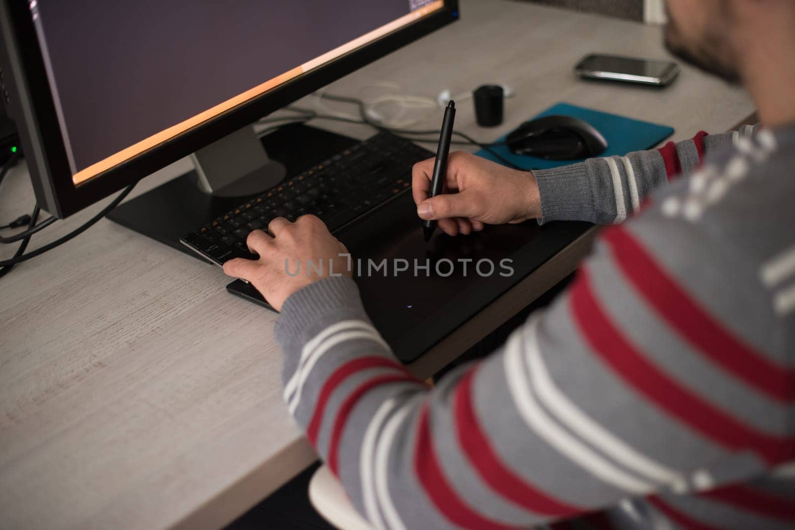 Young graphic designer working on a digital tablet and a computer