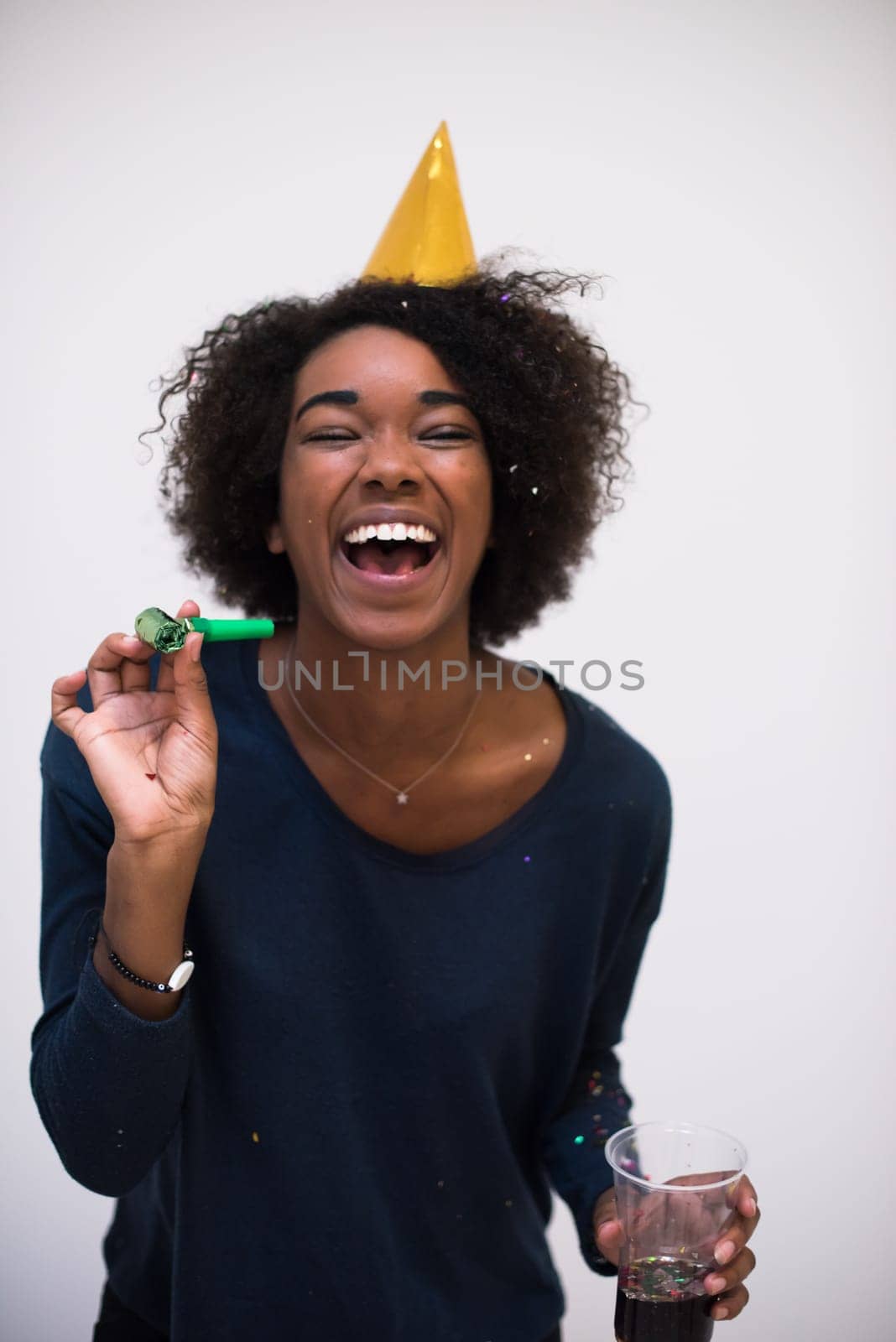 happy young woman celebrating new years eve party while blowing confetti