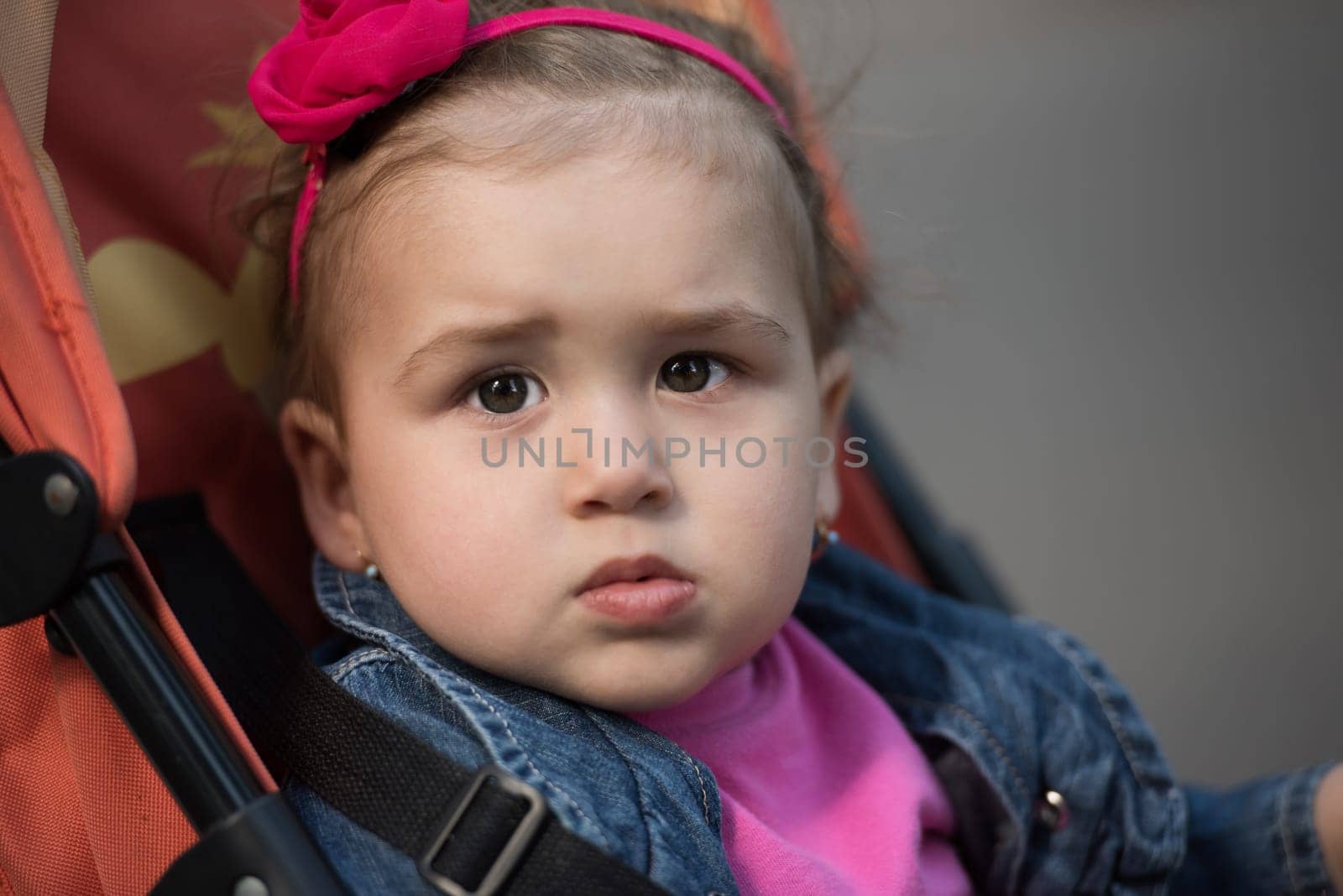 little and very beautiful baby girl sitting in the pram and waiting for mom