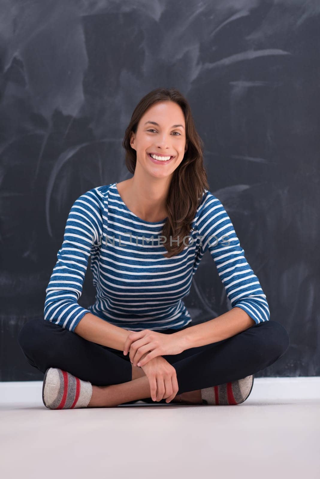 portrait of a young woman sitting in front of chalk drawing board