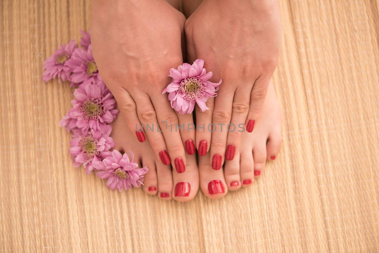 Closeup photo of a female feet and hands at spa salon on pedicure and manicure procedure