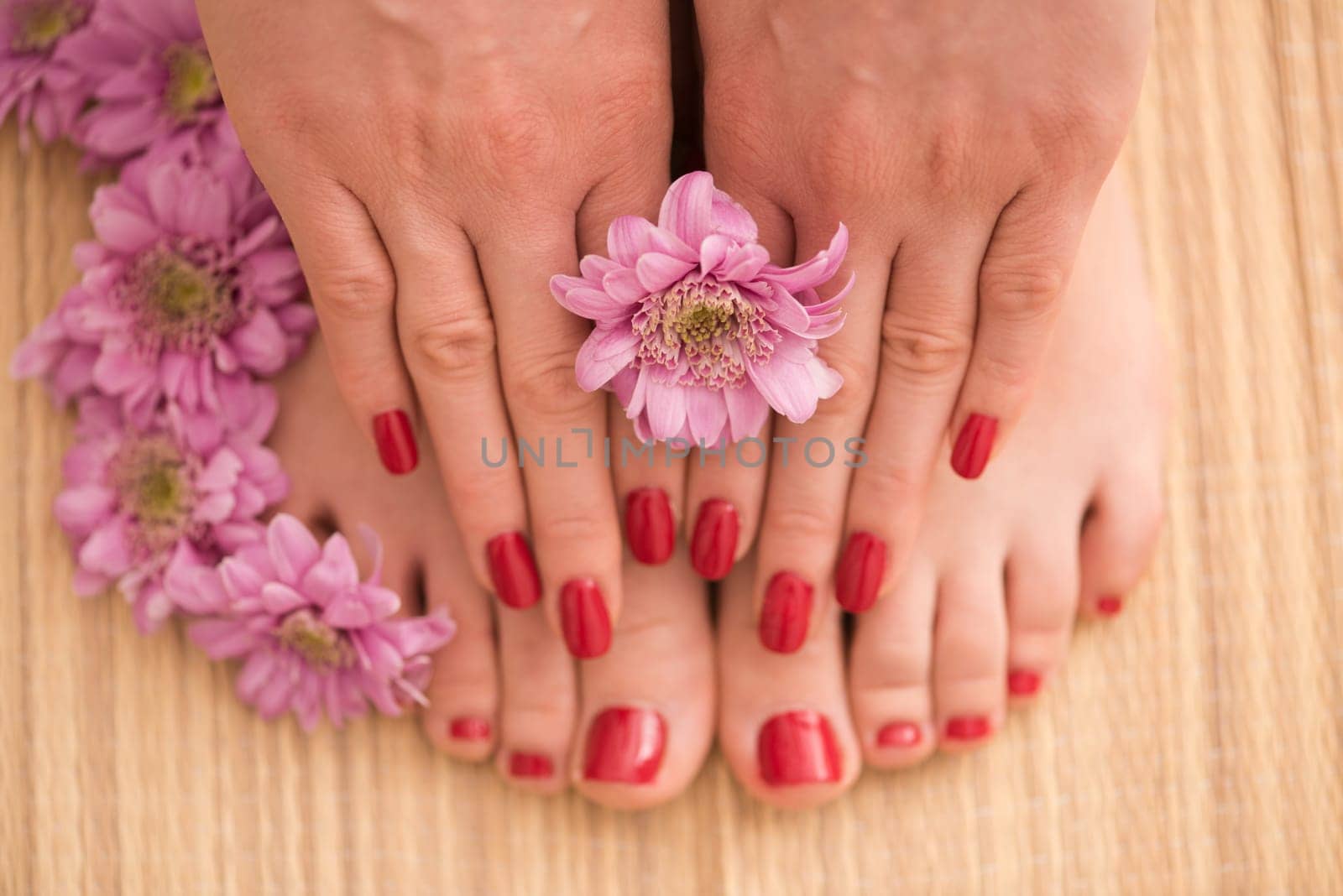 Closeup photo of a female feet and hands at spa salon on pedicure and manicure procedure