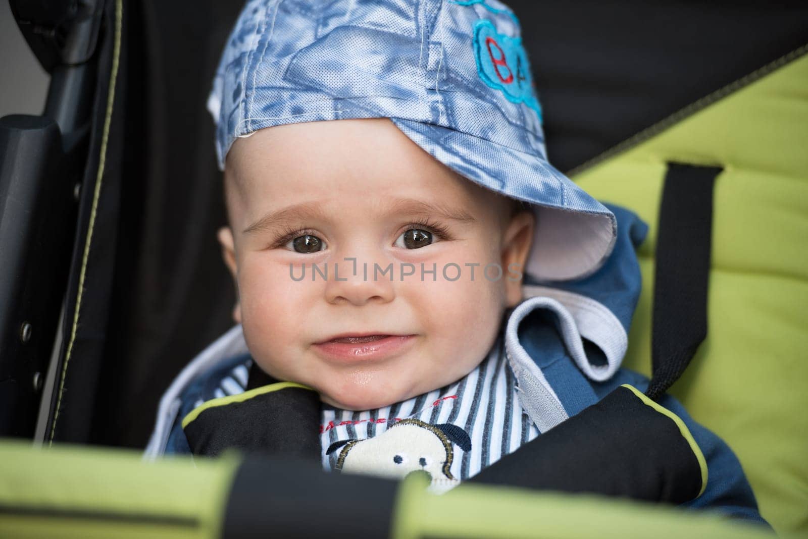 little and very beautiful baby boy sitting in the pram and waiting for mom