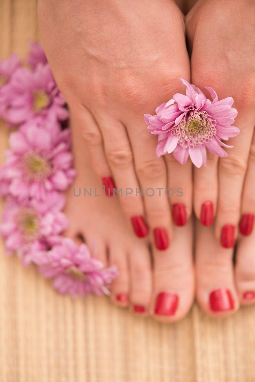 Closeup photo of a female feet and hands at spa salon on pedicure and manicure procedure