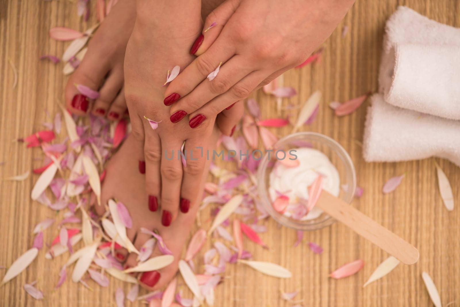 Closeup photo of a female feet and hands at spa salon on pedicure and manicure procedure