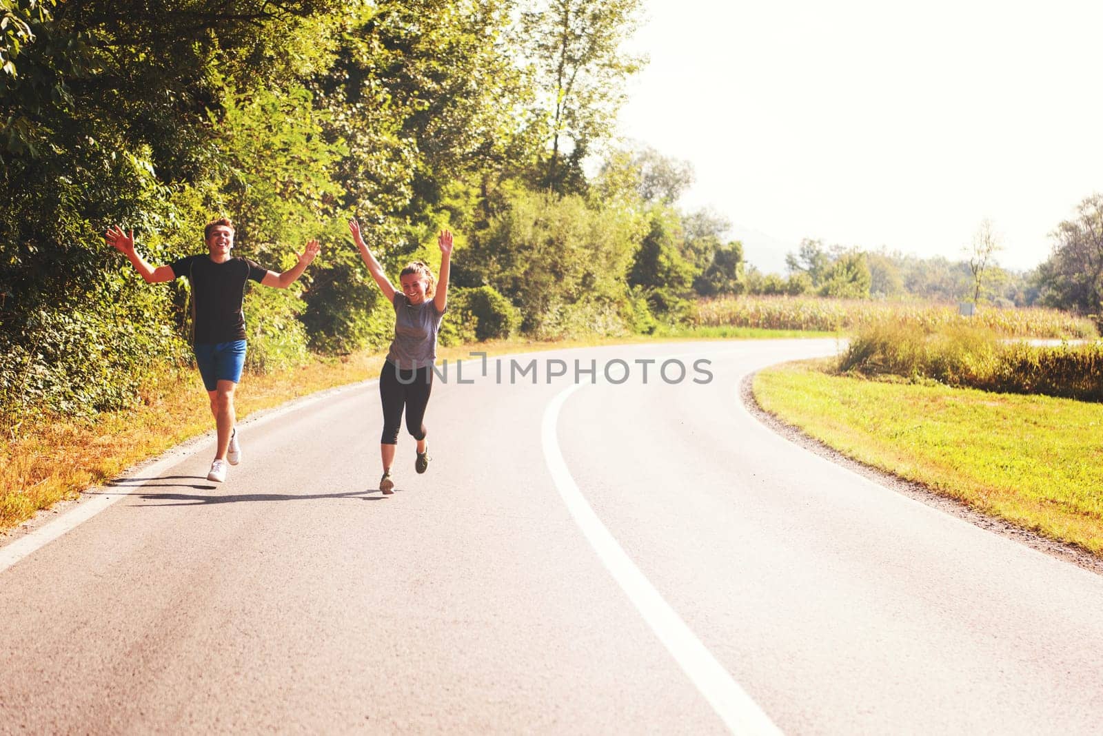 young couple enjoying in a healthy lifestyle while jogging along a country road, exercise and fitness concept
