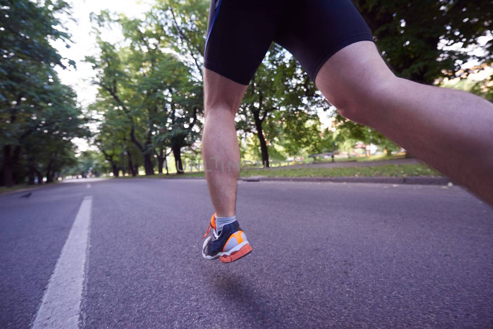healthy athlete man jogging at morning on empty  roat in the city