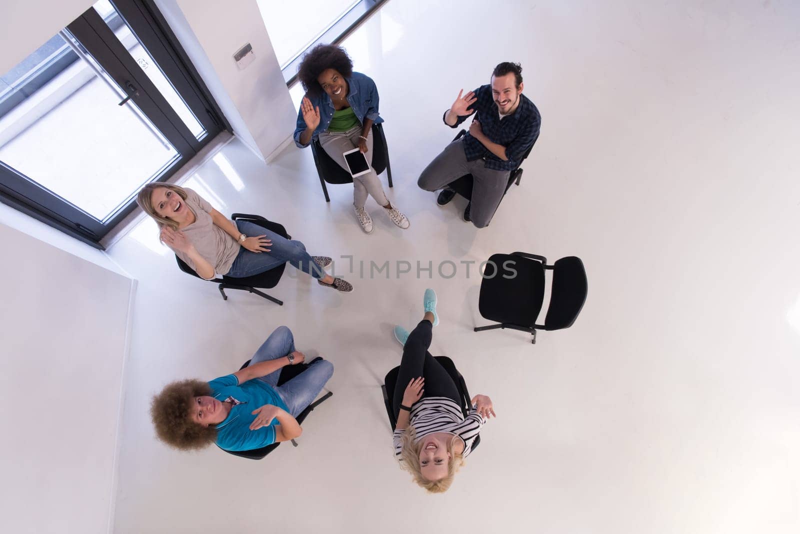 Multiethnic startup business team on meeting in modern bright office interior brainstorming, working on laptop and tablet computer top view