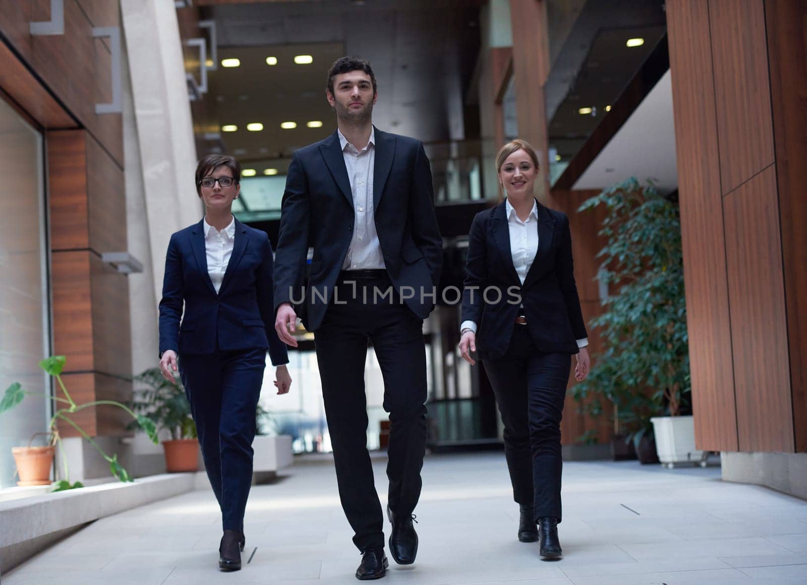 young business people team walking, group of people on modern office hall interior