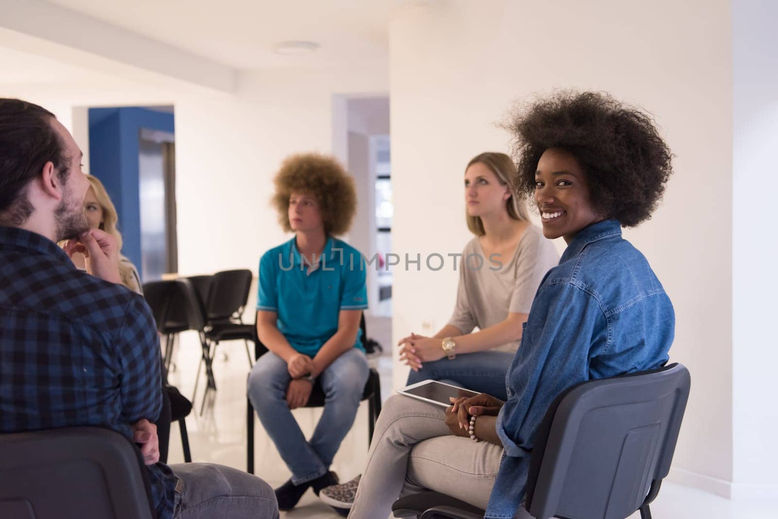 Multiethnic startup business team on meeting in modern bright office interior brainstorming, working on laptop and tablet computer