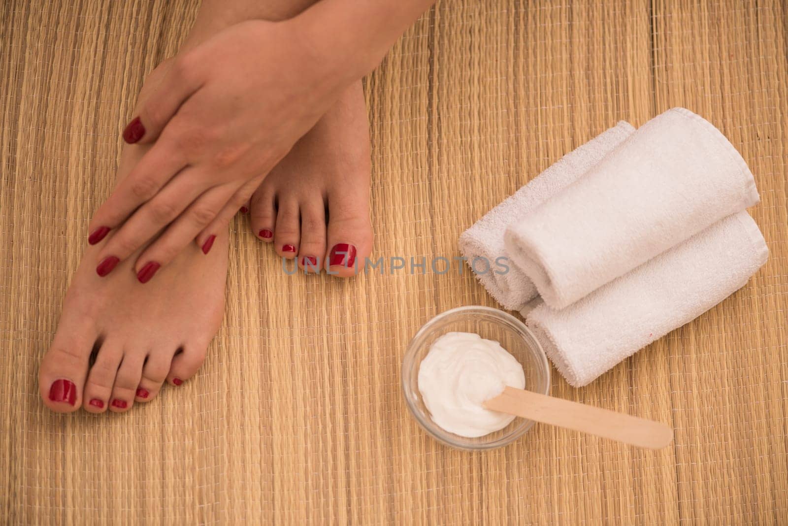 Closeup photo of a female feet and hands at spa salon on pedicure and manicure procedure