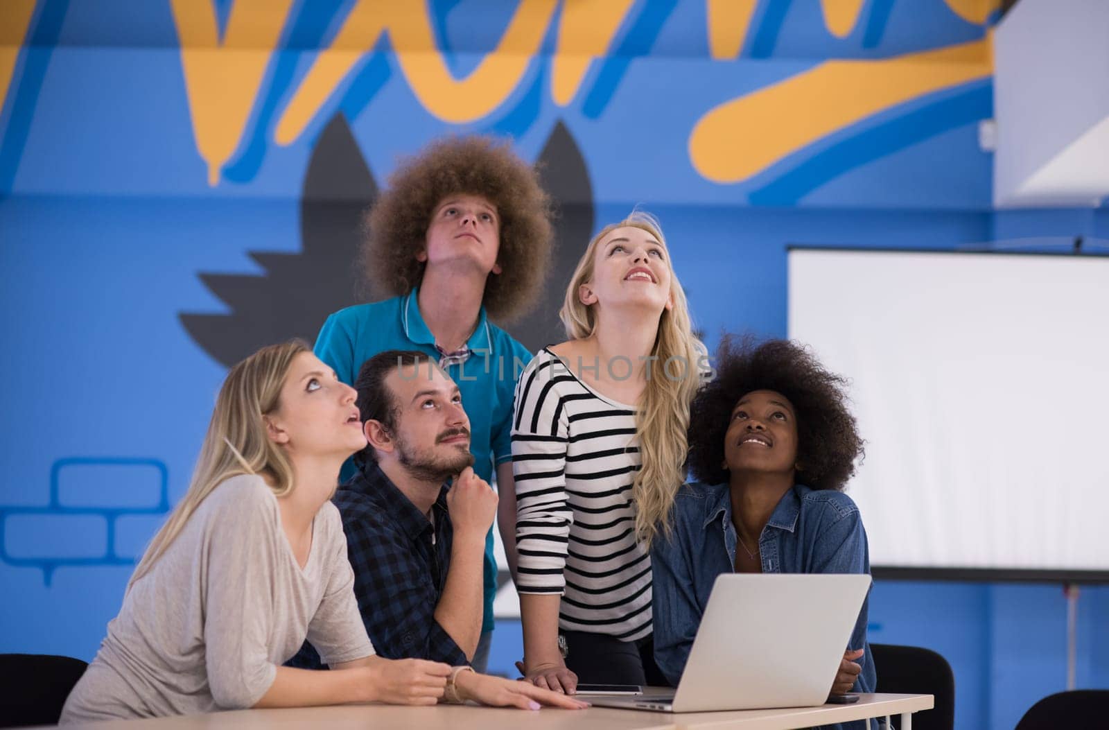 Multiethnic startup business team on meeting in modern bright office interior brainstorming, working on laptop and tablet computer