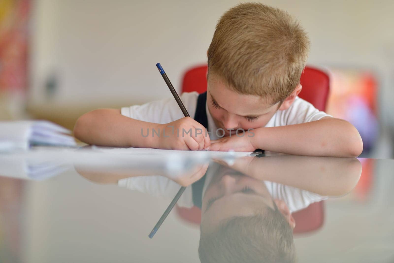 young mom woman doing home work with elementary school grade boy at home in kitchen