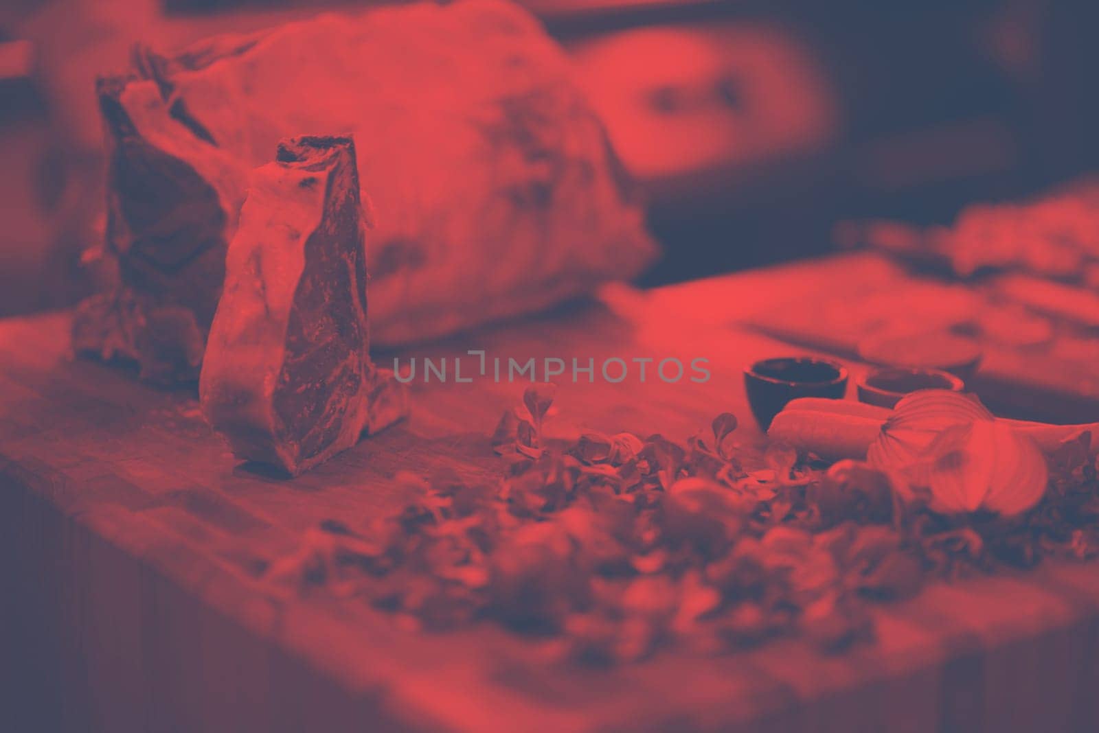 Juicy slice of raw steak  with vegetables around on a wooden table