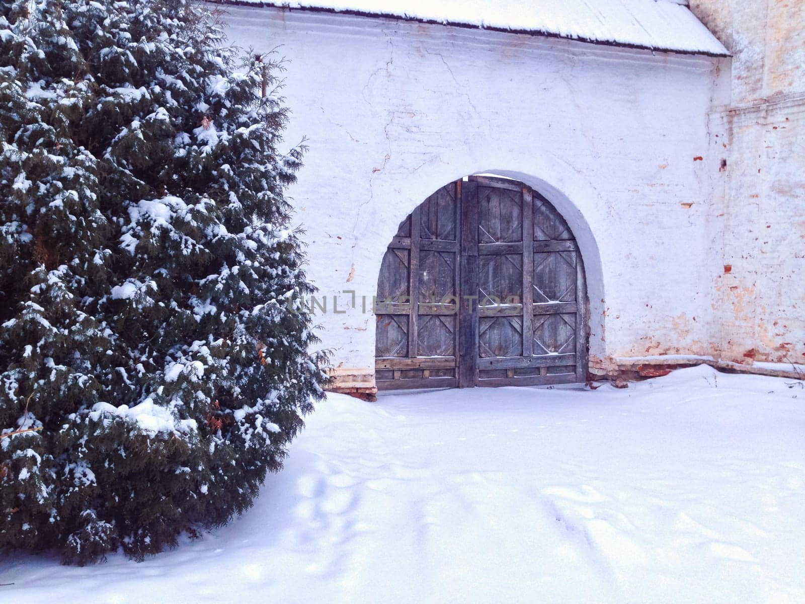Old gate of monastery in winter. Lots of snow, Russia.