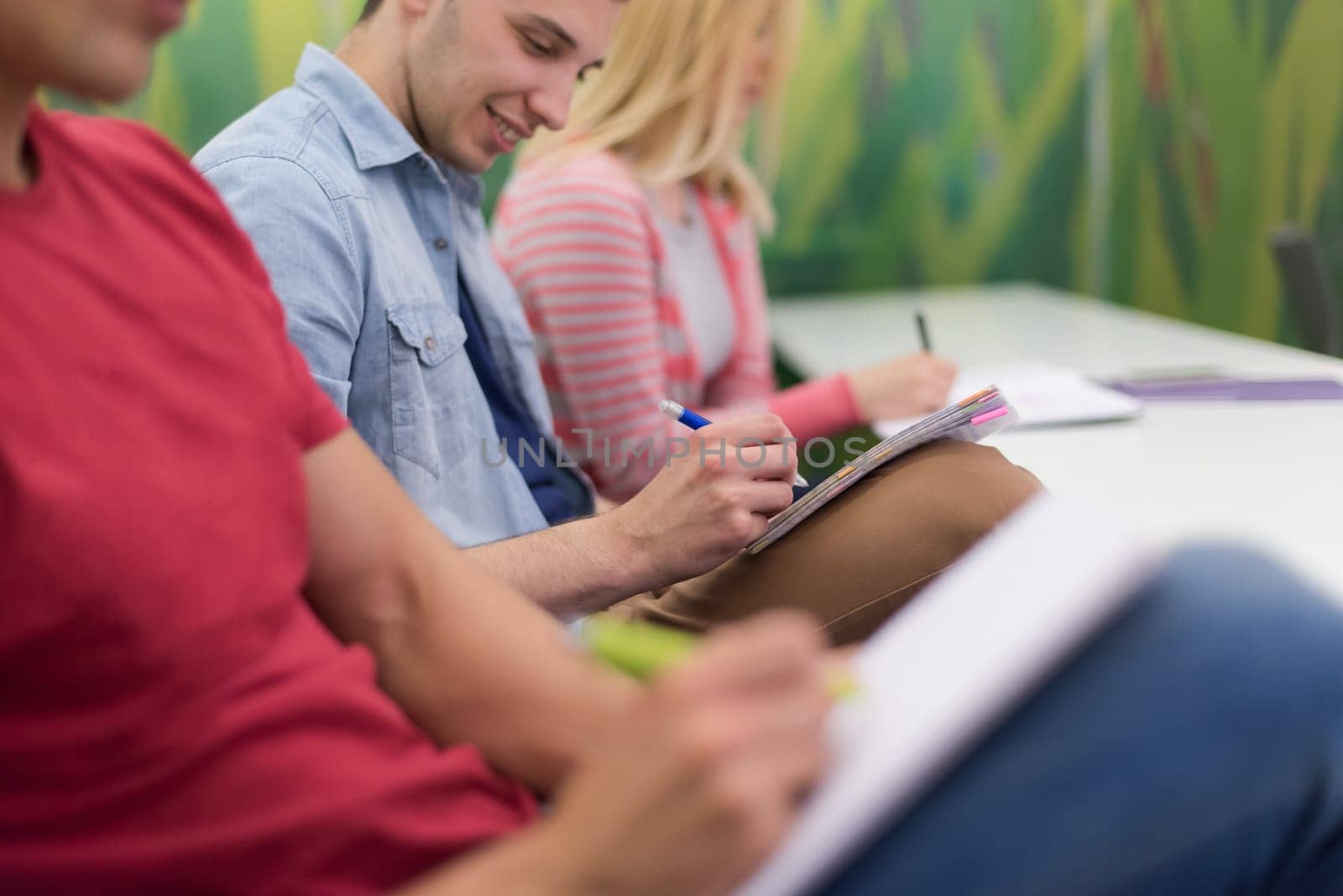 male student taking notes in classroom. business education concept, casual young businessman on seminar training