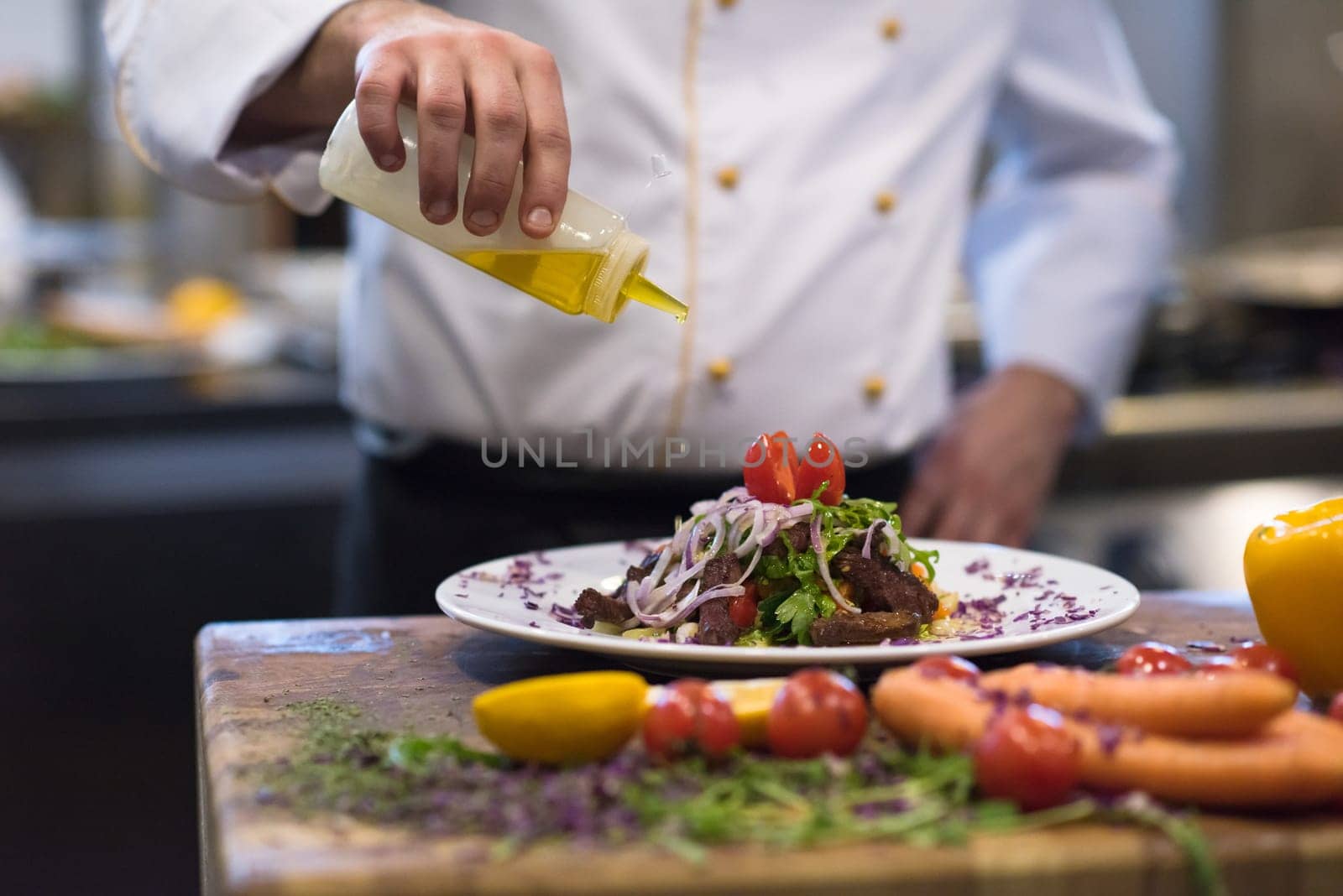 Chef finishing steak meat plate with Finally dish dressing and almost ready to serve at the table