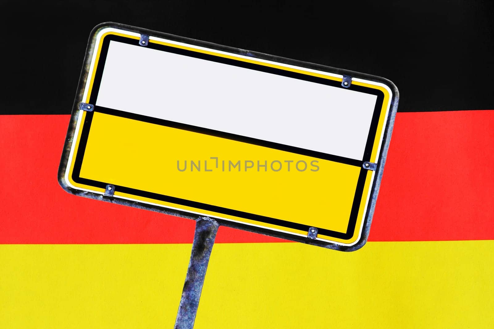 An empty yellow German street sign in front of Germany flag