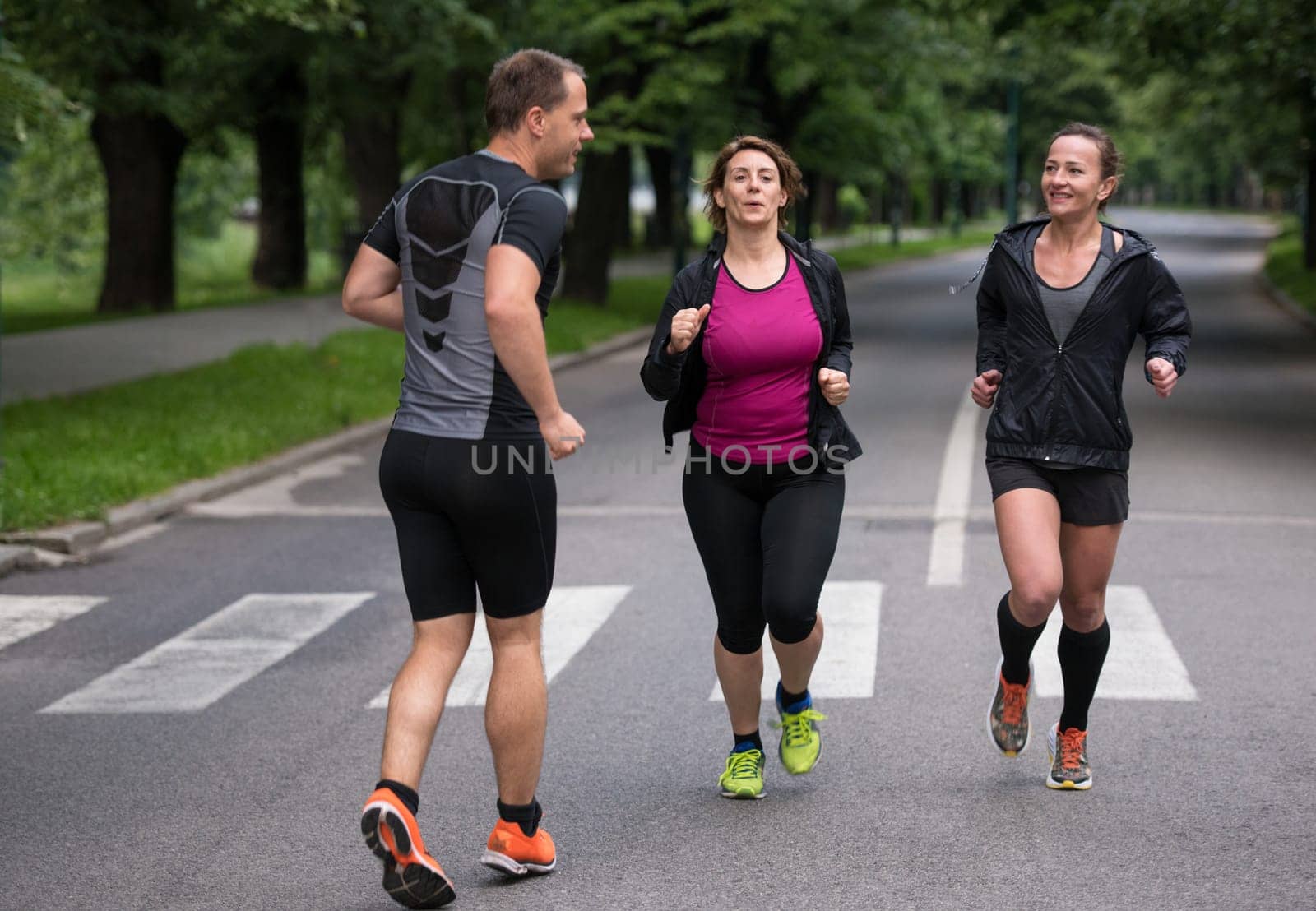 group of healthy people jogging in city park, runners team on morning training