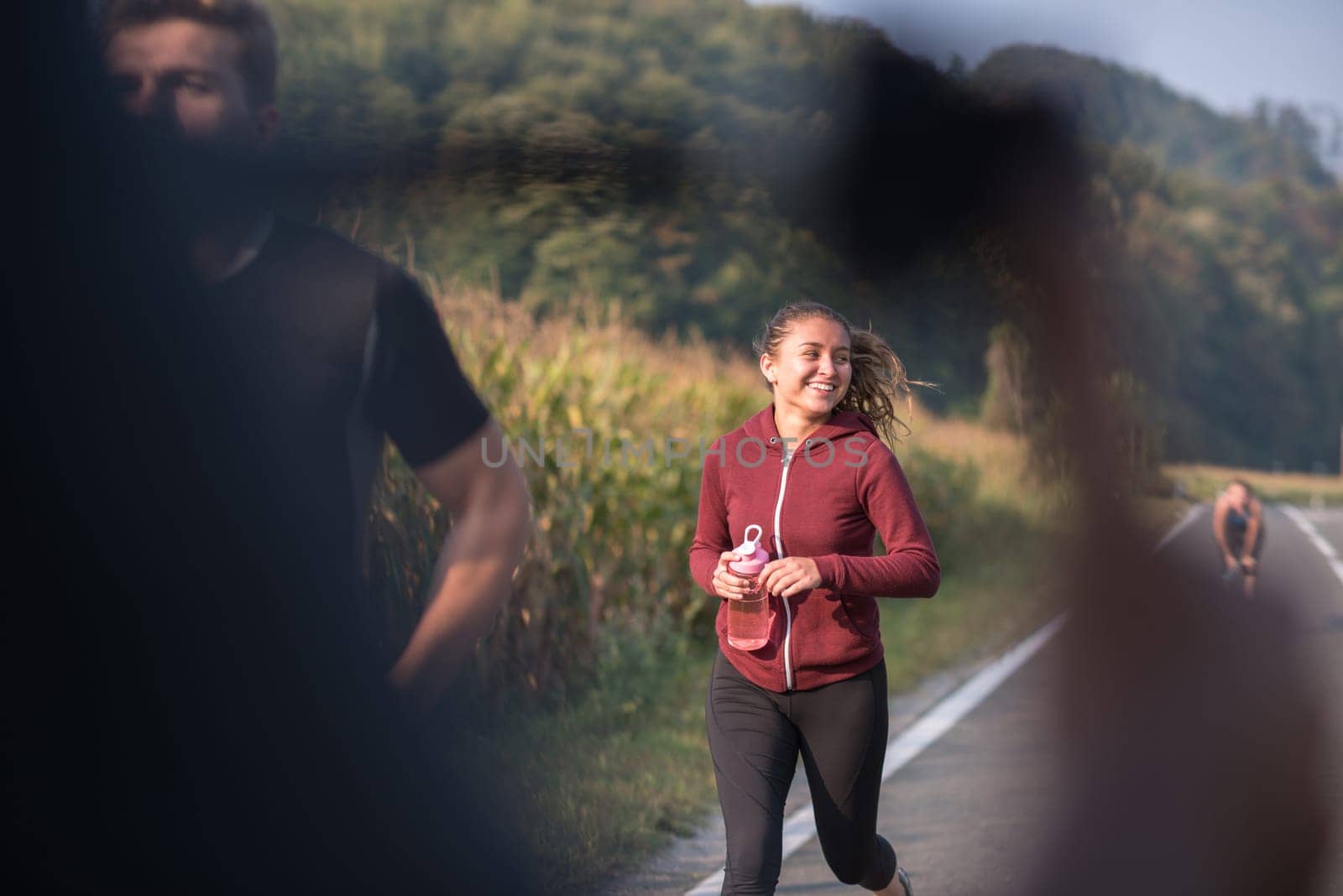 group of young people jogging on country road runners running on open road on a summer day