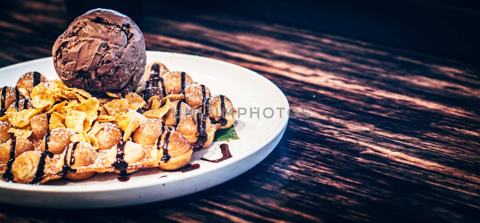tasty pancakes with chocolate ice cream crispy waffle whipped cream with brownies cherry almond and chocolate syrup on top with corn-flex . summer holiday dessert Menu for kid  .