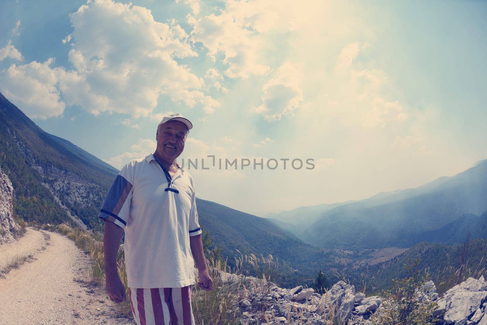 seinor male hiker relaxing in nature while  walking tour on beautiful summer day on canyon of  dried riverbed