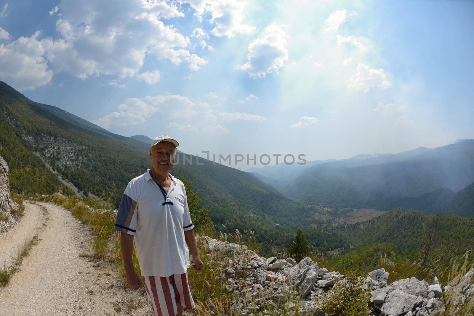 seinor male hiker relaxing in nature while  walking tour on beautiful summer day on canyon of  dried riverbed