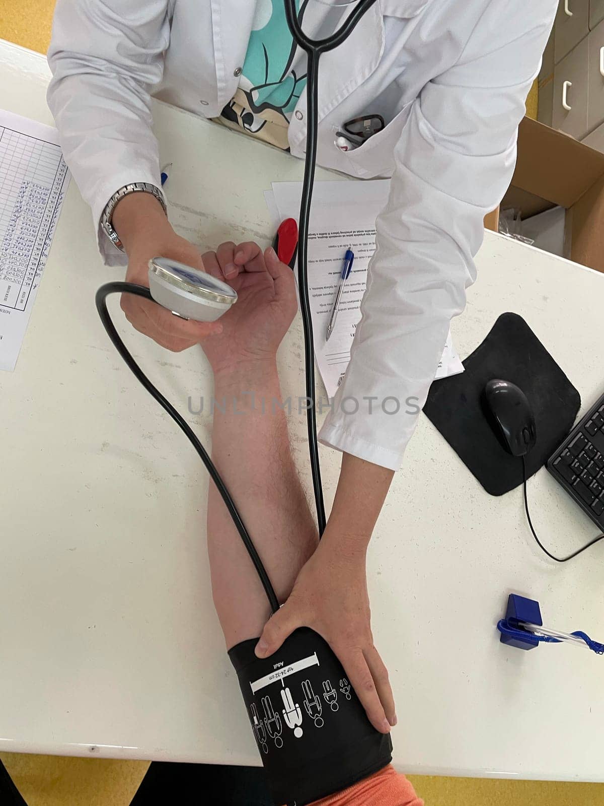 Female doctor in medical facemask measure blood pressure with electronic monitor in hospital. Caring woman GP help examine do checkup of elderly client in clinic. Healthcare, hypertension concept. High quality photo