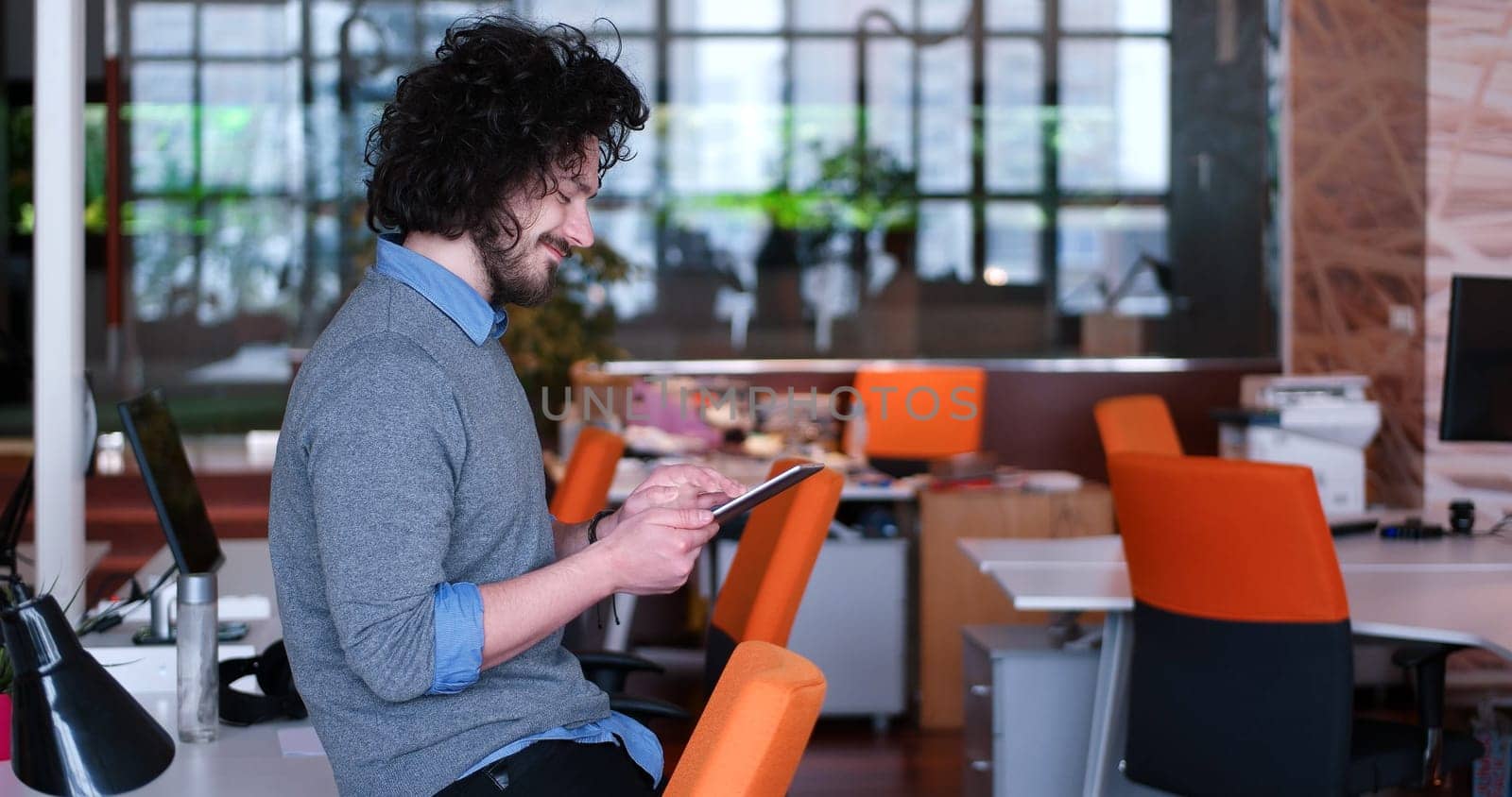 young casual businessman using tablet computer in startup office