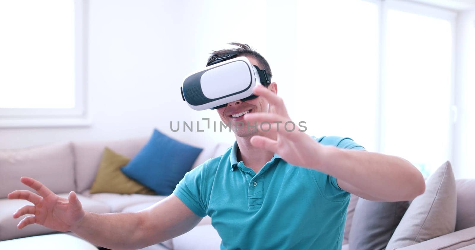 happy man getting experience using VR-headset glasses of virtual reality at home