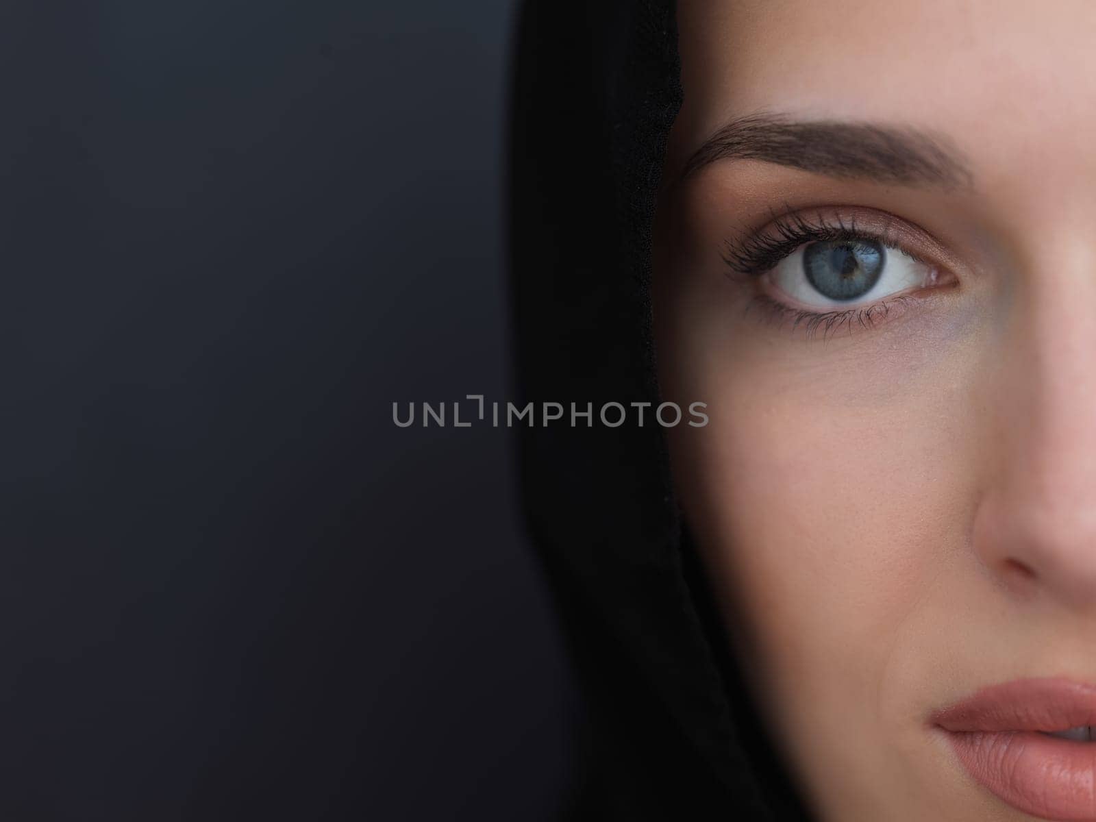 Portrait of modern young muslim woman in black abaya. Arab girl wearing traditional clothes and posing in front of black chalkboard. Representing modern and rich arabic lifestyle