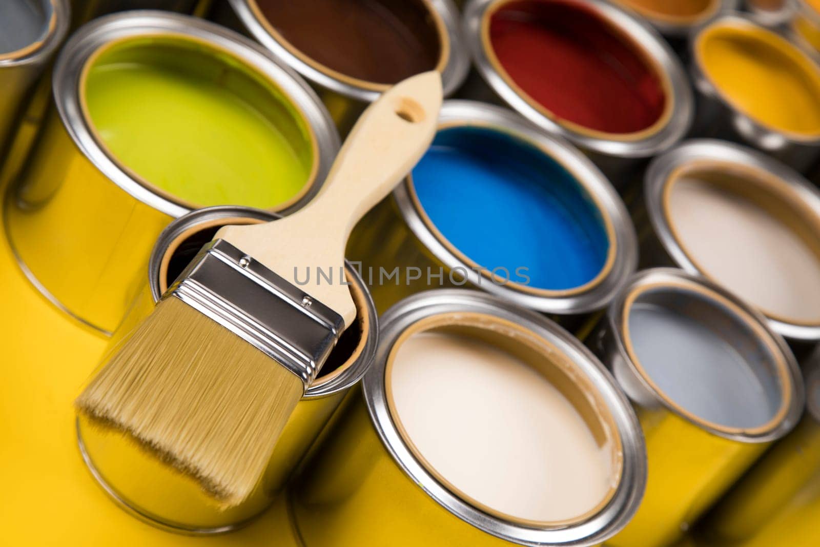 Tin cans with paint, brushes and bright palette of colors