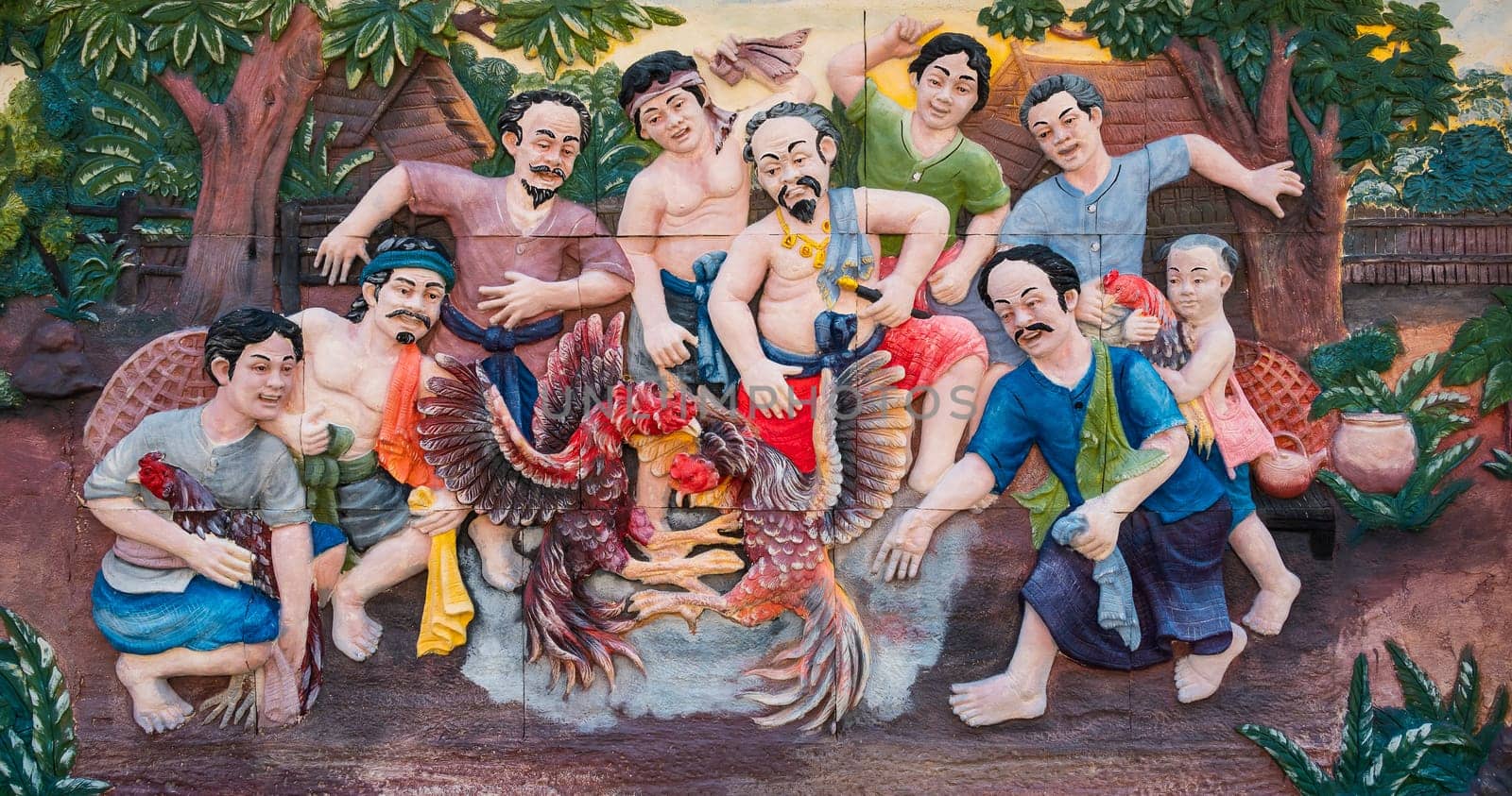 Bangkok, Thailand - April 15, 2021 : Stone carving of traditional Thai rural cockfighting on temple wall in Bangkok, Thailand