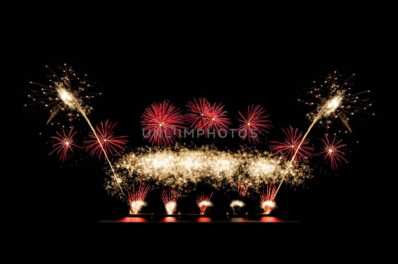 Red ang golden fireworks display on black sky with copy space for greeting text. Celebration and anniversary concept