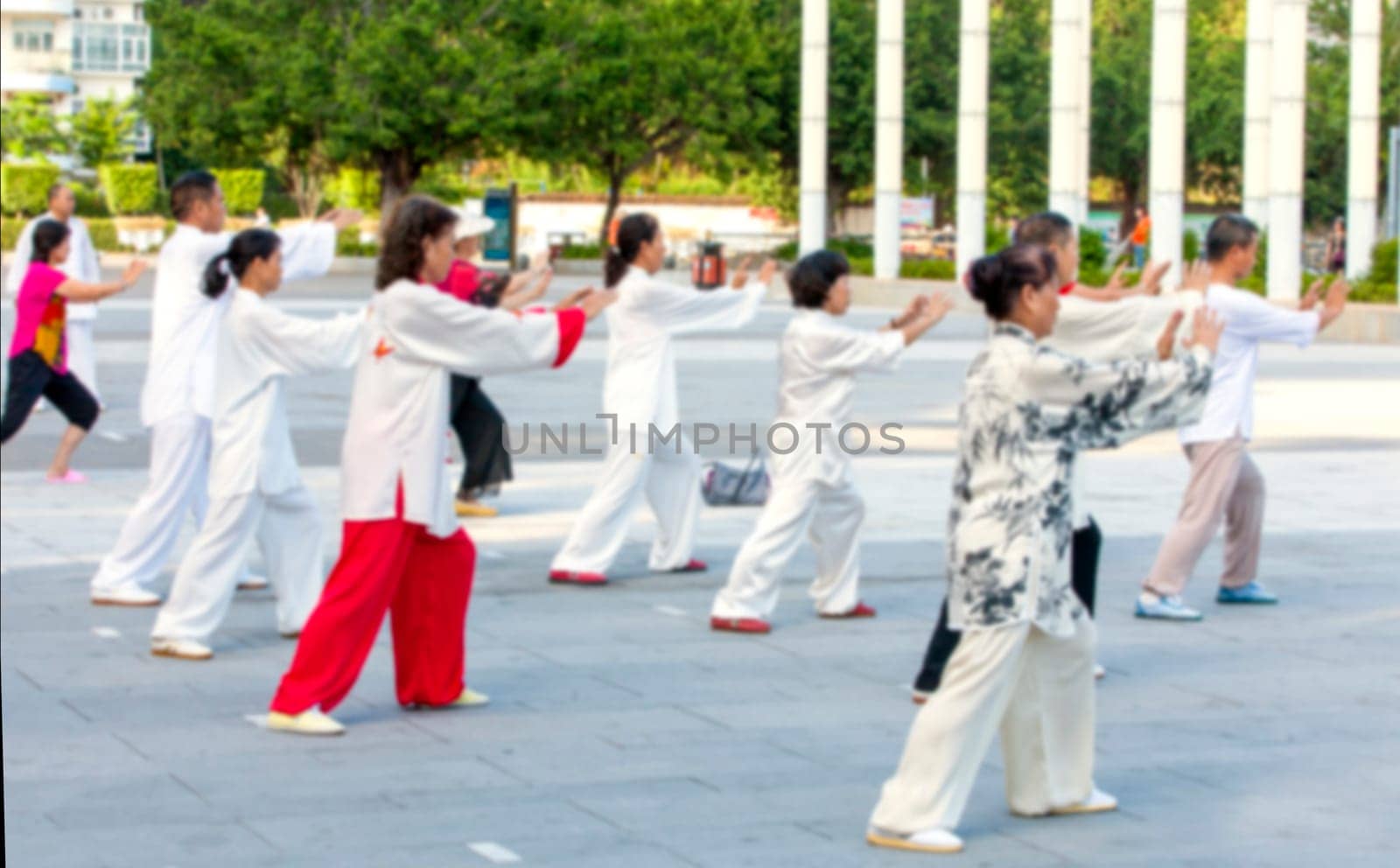 The Blurred foto  Women and men in the street in the Park gymnastics
