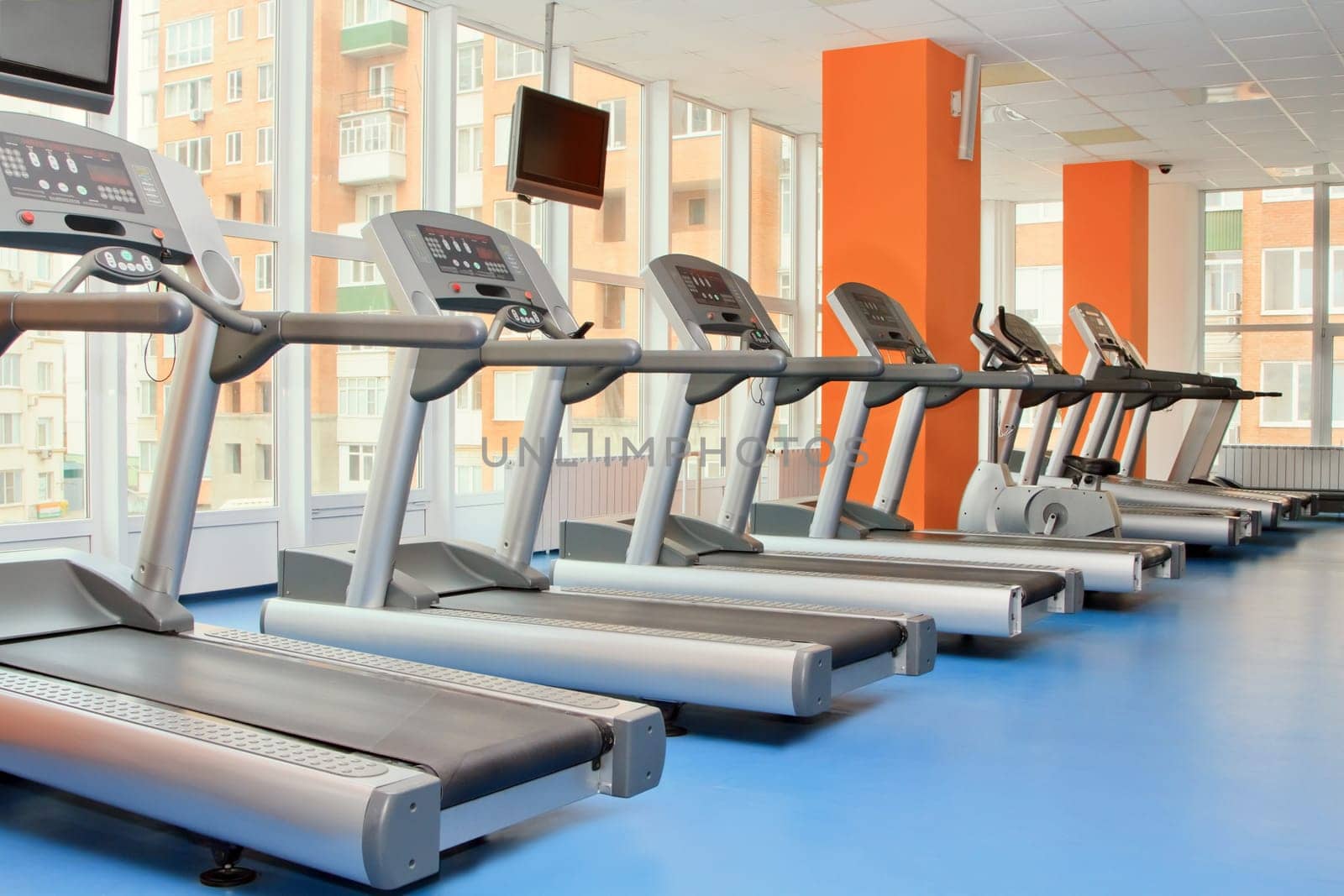 Gym with windows and running machines in fitness center