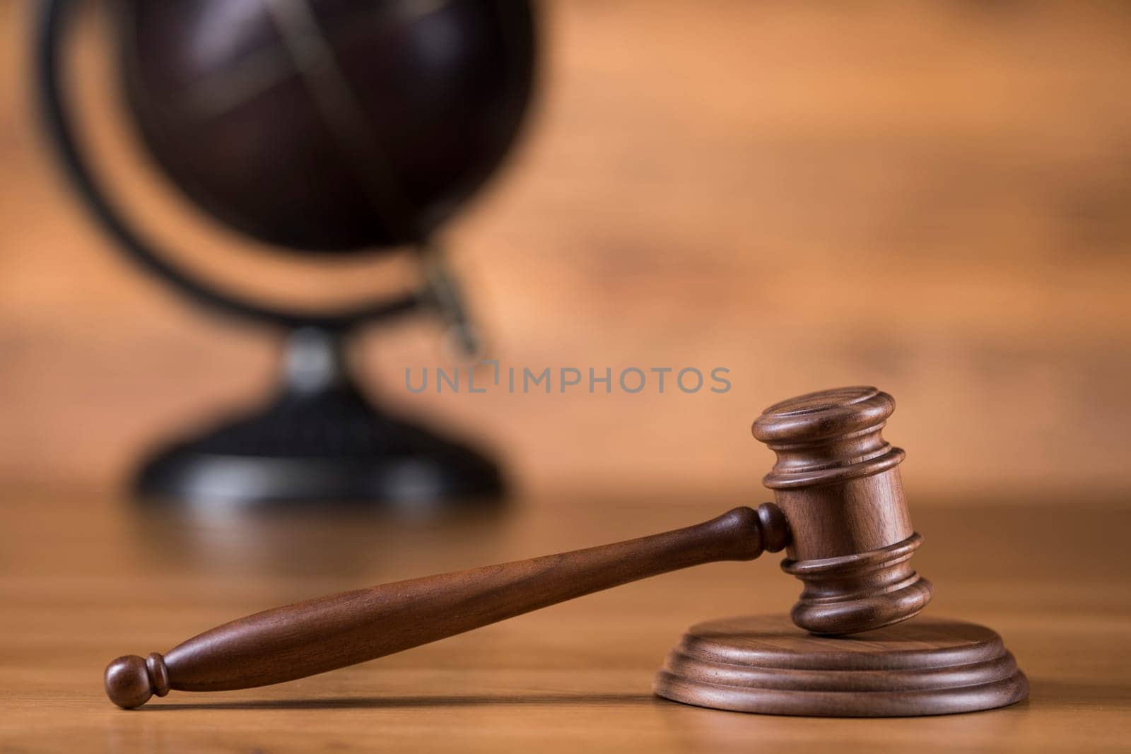 Law theme, mallet of judge, wooden gavel, globe background