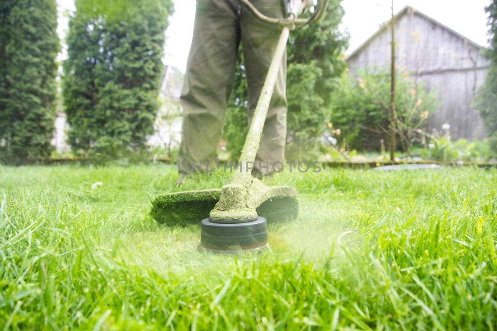 Mowing the grass with a lawn mower. Garden work concept background.