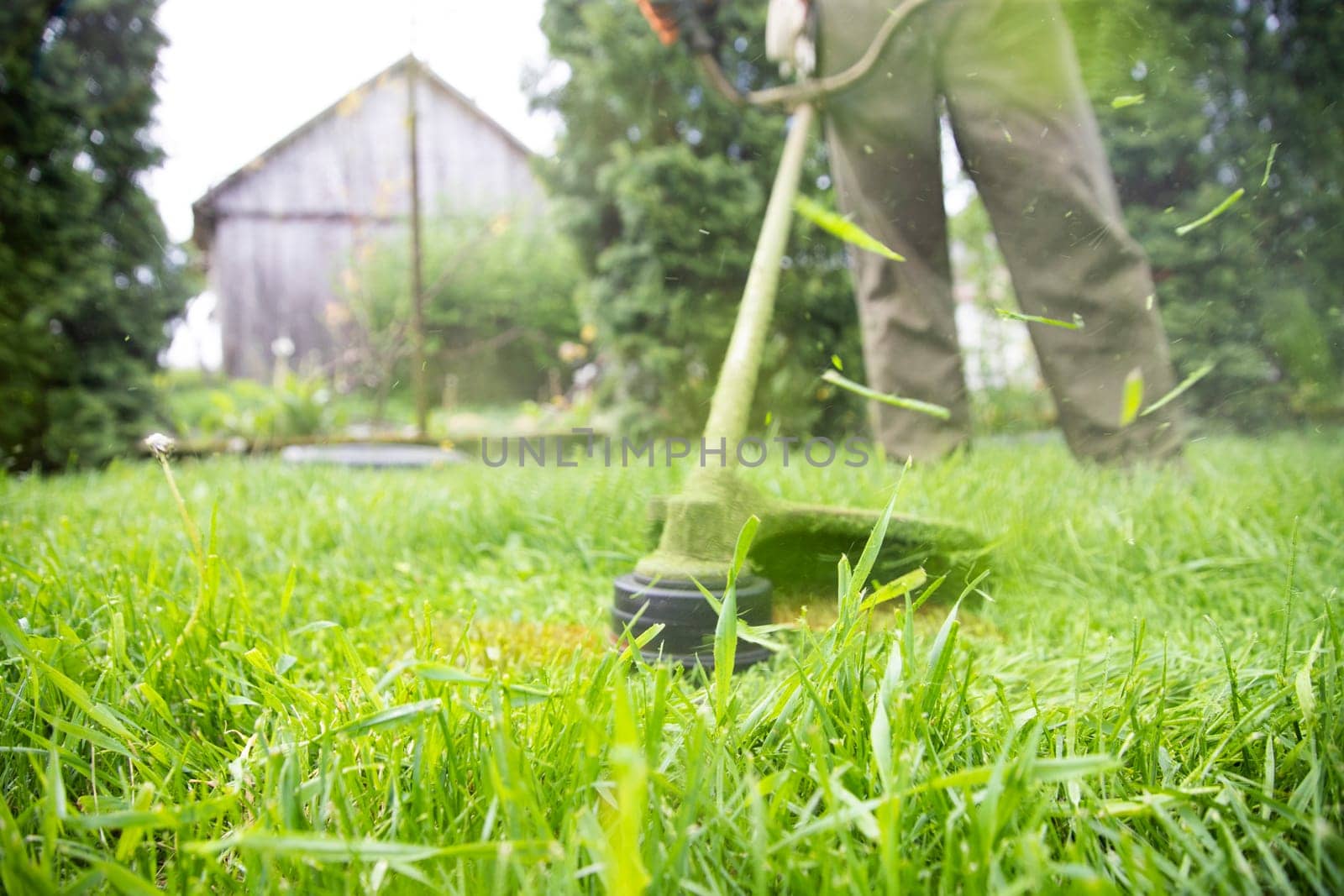 Mowing the grass with a lawn mower. Garden work concept background.