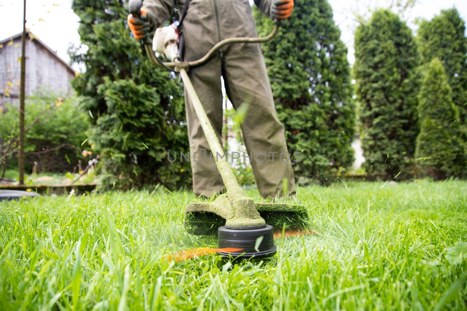 Mowing the grass with a lawn mower. Garden work concept background.