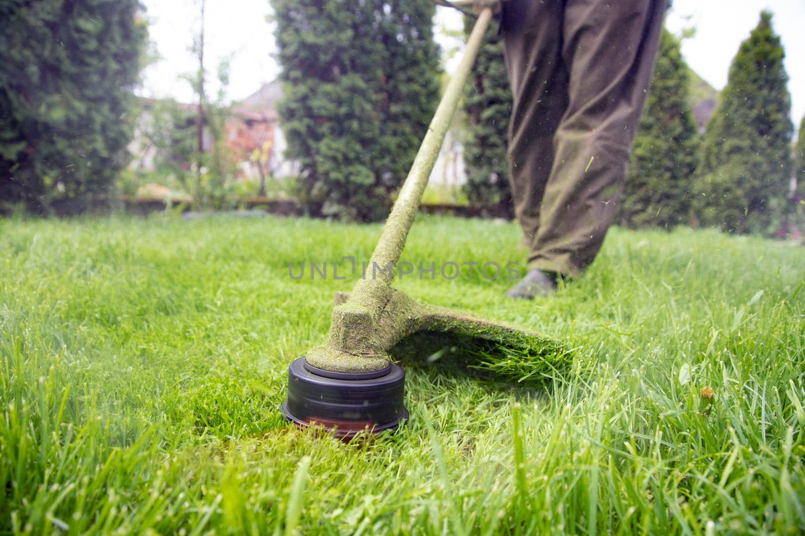Mowing the grass with a lawn mower. Garden work concept background.
