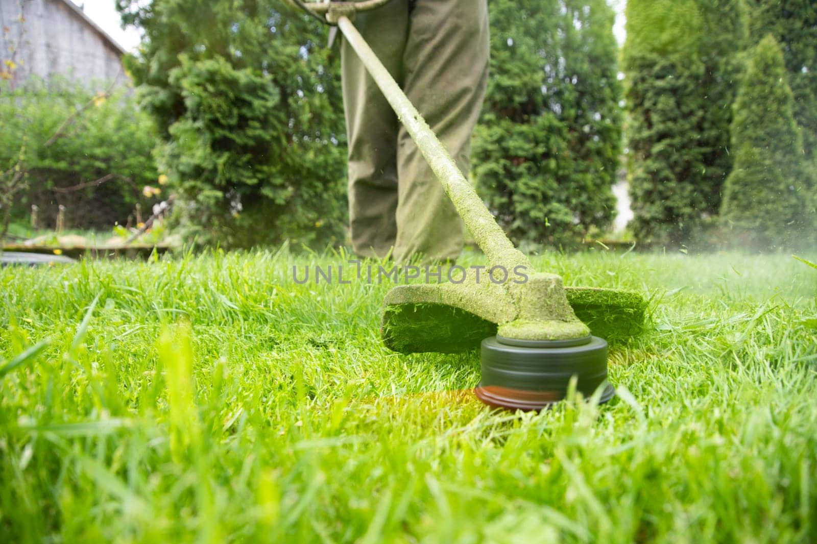 Mowing the grass with a lawn mower. Garden work concept background.