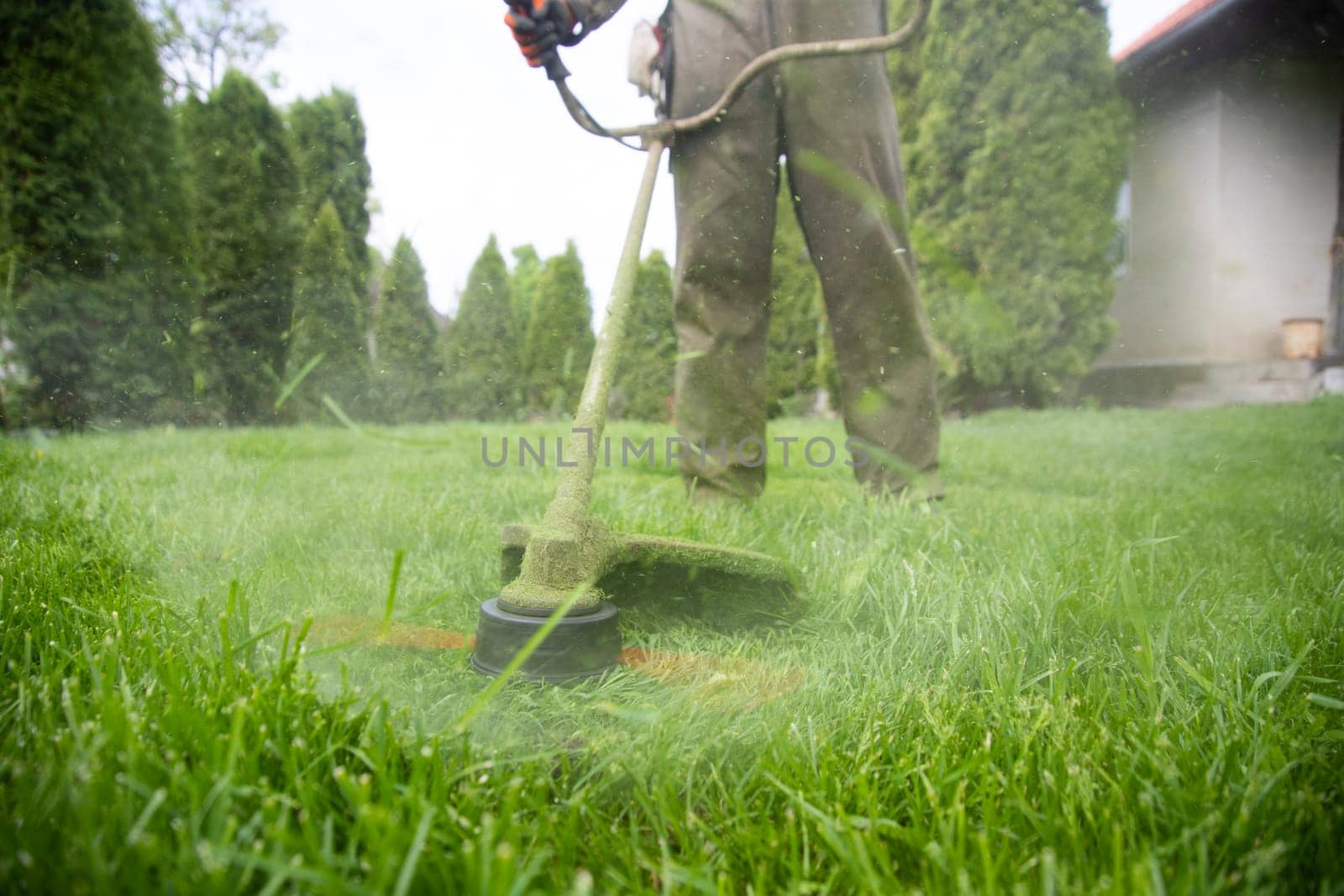 Mowing the grass with a lawn mower. Garden work concept background.