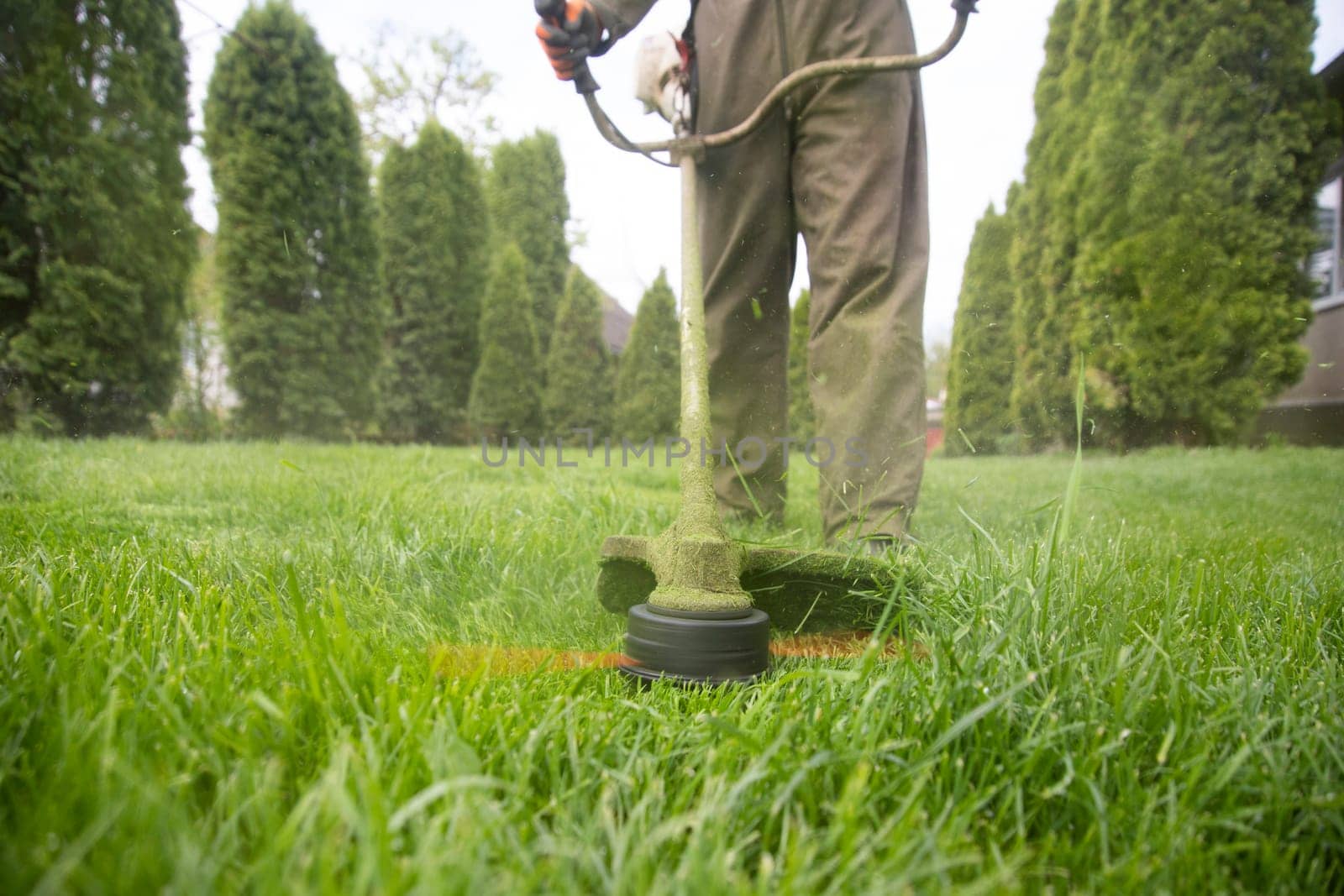 Mowing the grass with a lawn mower. Garden work concept background.