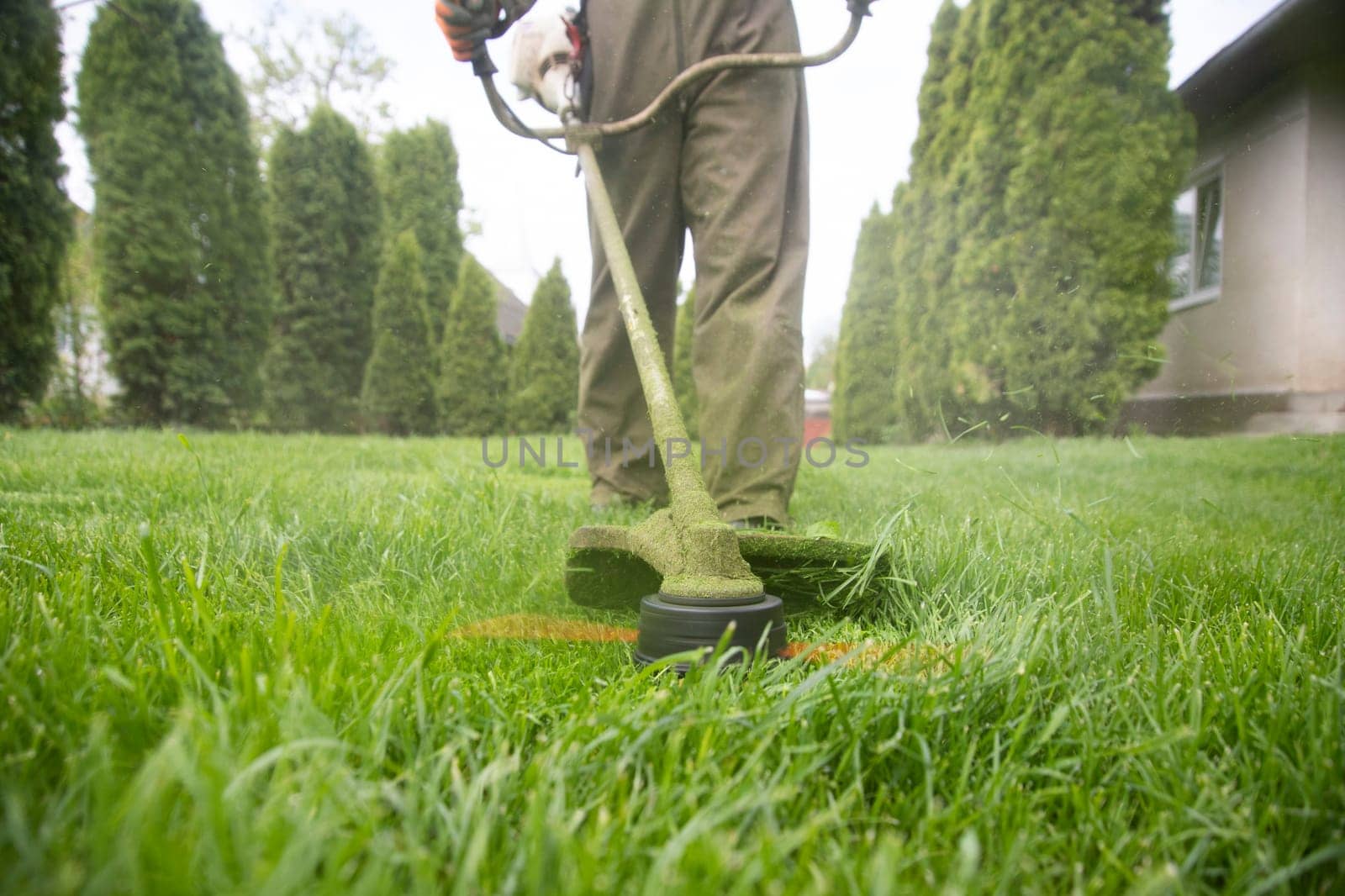 Mowing the grass with a lawn mower. Garden work concept background.