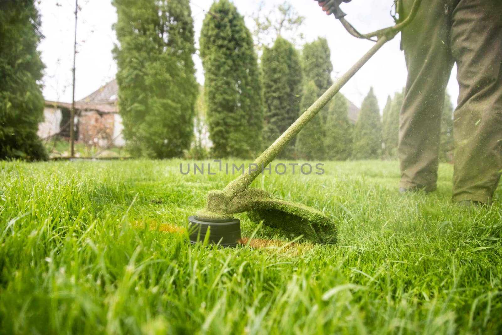 Mowing the grass with a lawn mower. Garden work concept background.