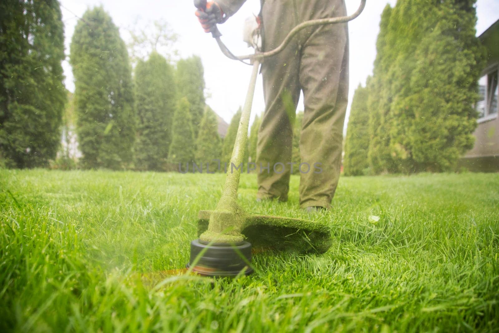 Mowing the grass with a lawn mower. Garden work concept background.