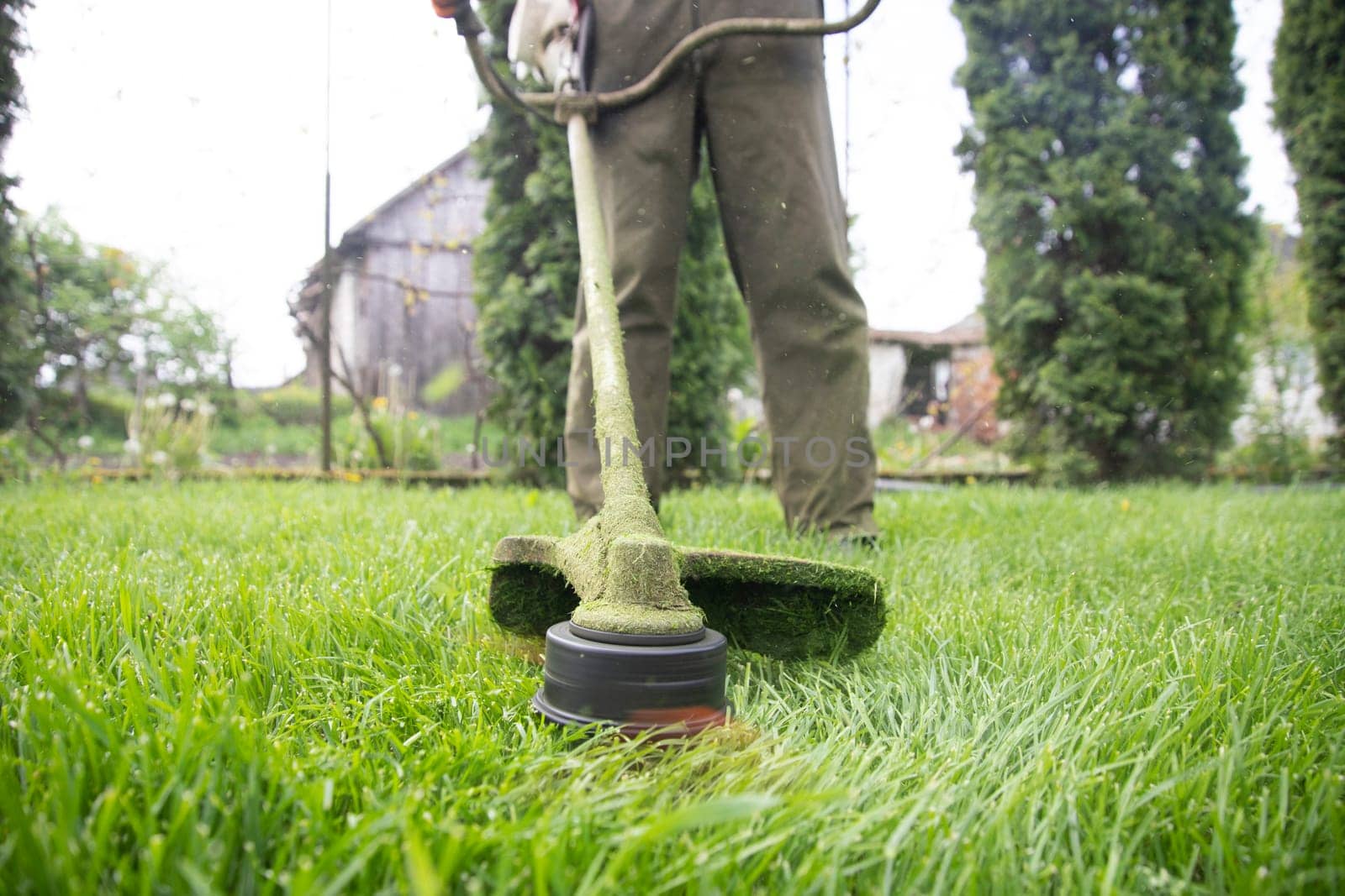 Mowing the grass with a lawn mower. Garden work concept background.