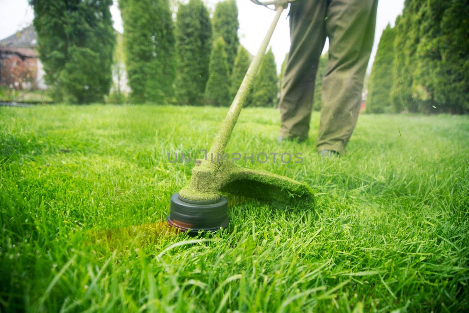 Mowing the grass with a lawn mower. Garden work concept background.