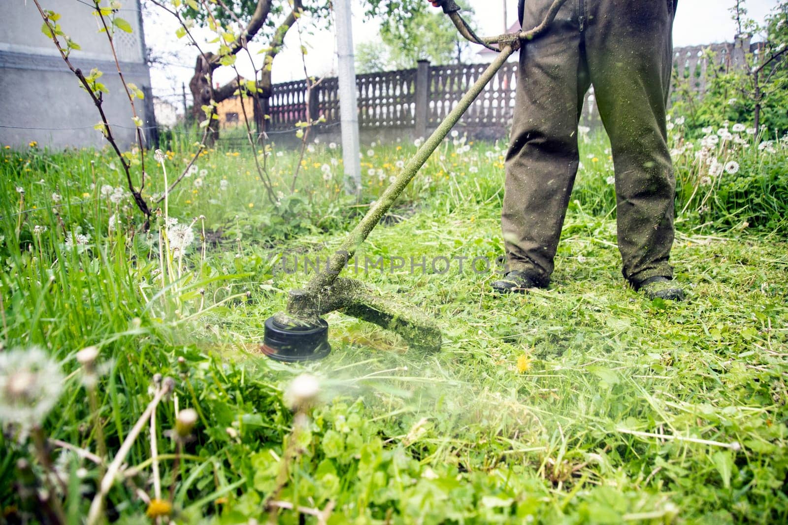 Mowing the grass with a lawn mower. Garden work concept background.